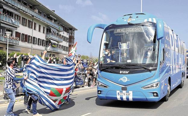 Seguidores de la Real ondean la bandera en el barrio de Amute de Hondarribia al paso del autocar txuri-urdin.. 