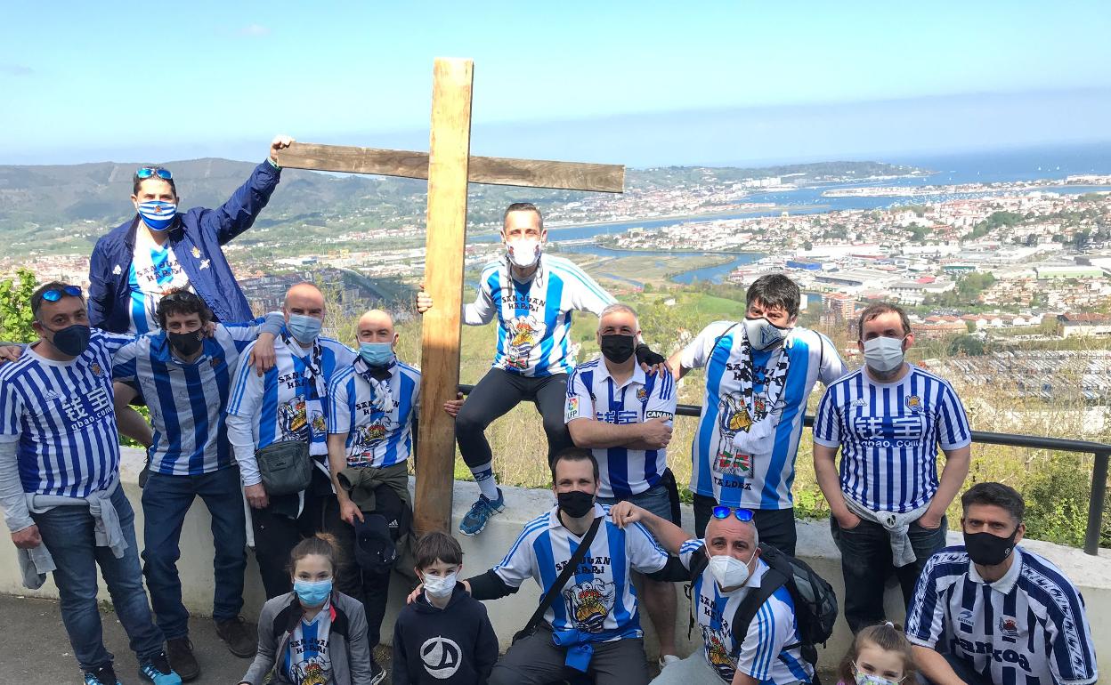 Fran Baños, en el medio de la foto, sujeta la cruz acompañado del resto de gente de la peña Irungo San Juan Harri Taldea.