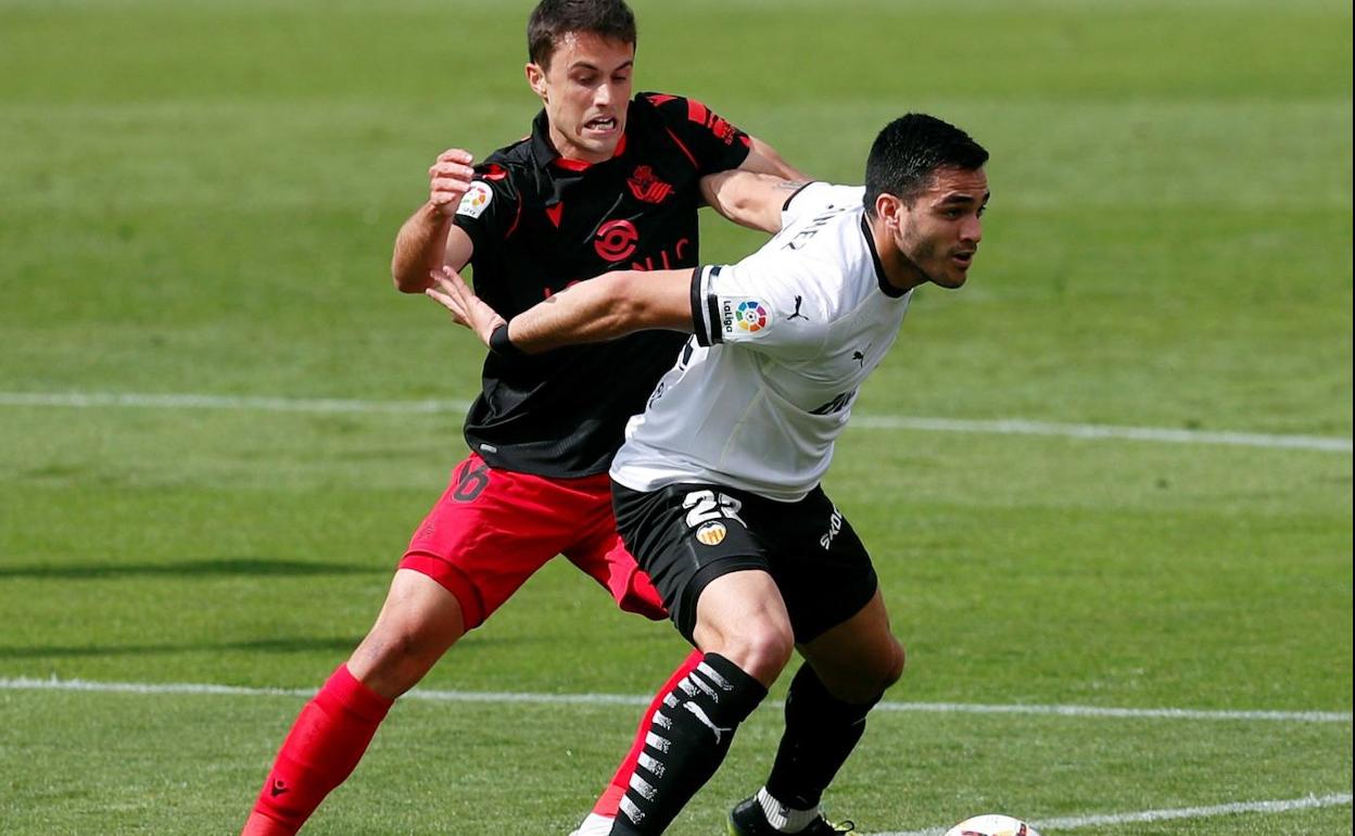 Ander Guevara trara de arrebatar el balón al valencianista Maxi Gómez. 