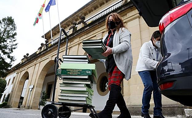 Ana Marín y una compañera descargan libros para los internos en la entrada de la cárcel de Martutene. 
