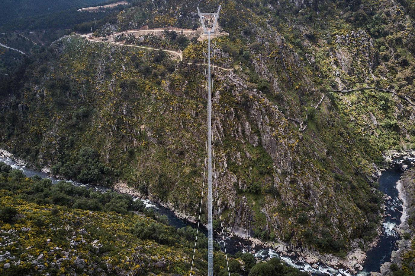 Portugal inauguró este jueves 29 de abril el puente peatonal suspendido más largo del mundo, a 175 metros sobre el río Paiva, en el norte, y que con sus 516 metros supera el récord establecido en 2017 por la pasarela Charles Kuonen de los Alpes suizos. El puente atraviesa un barranco granítico del municipio de Arouca y está formado por 127 planchas de rejilla con barandillas metálicas de 1,20 metros de ancho, sujetas por cables de acero a unos pilares en forma de 'V' situados a cada extremo.