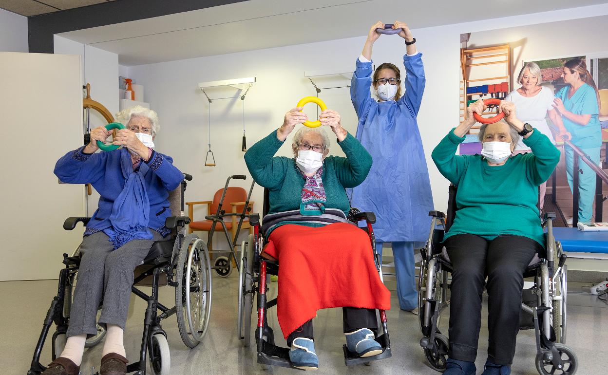 Guiomar Andreu posa junto a tres de sus pacientes en la residencia Residencia Gurena. 