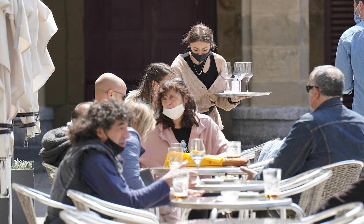 Un grupo de personas disfruta del buen tiempo en una terraza en San Sebastián.