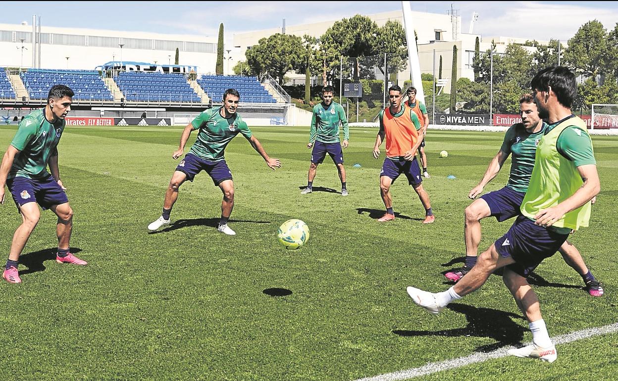 Silva pasa el balón a Merquelanz, a quien va a presionar Guevara, durante la sesión de ayer en las instalaciones del Real Madrid.