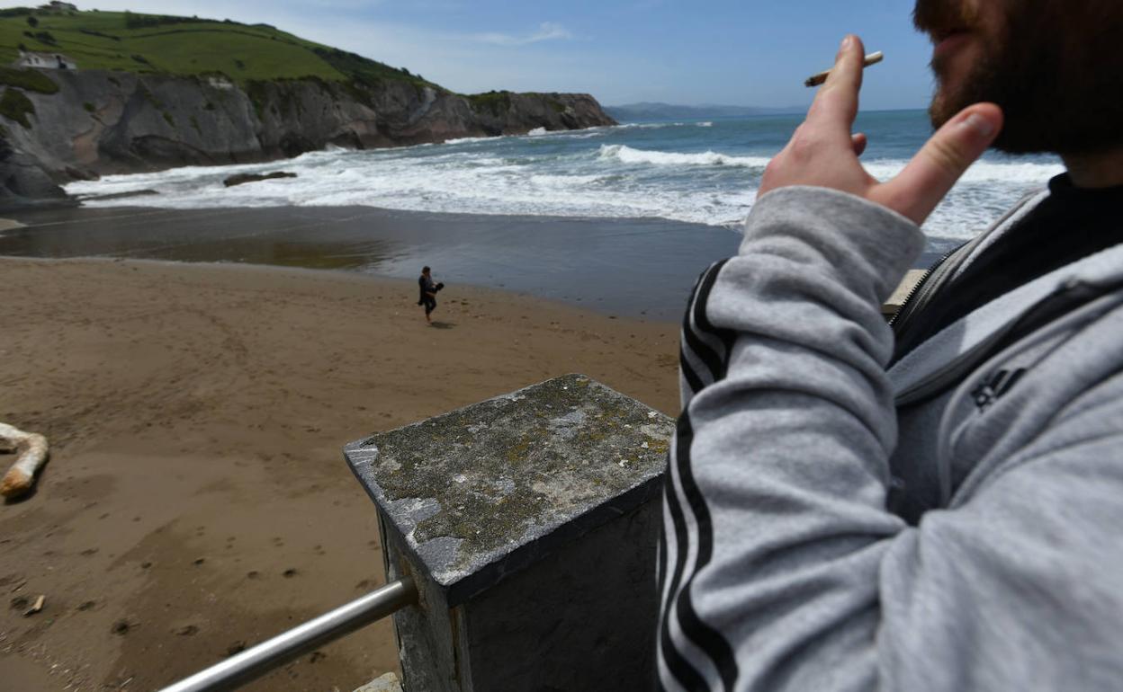 Un fumador en la playa de Itzurun de Zumaia-