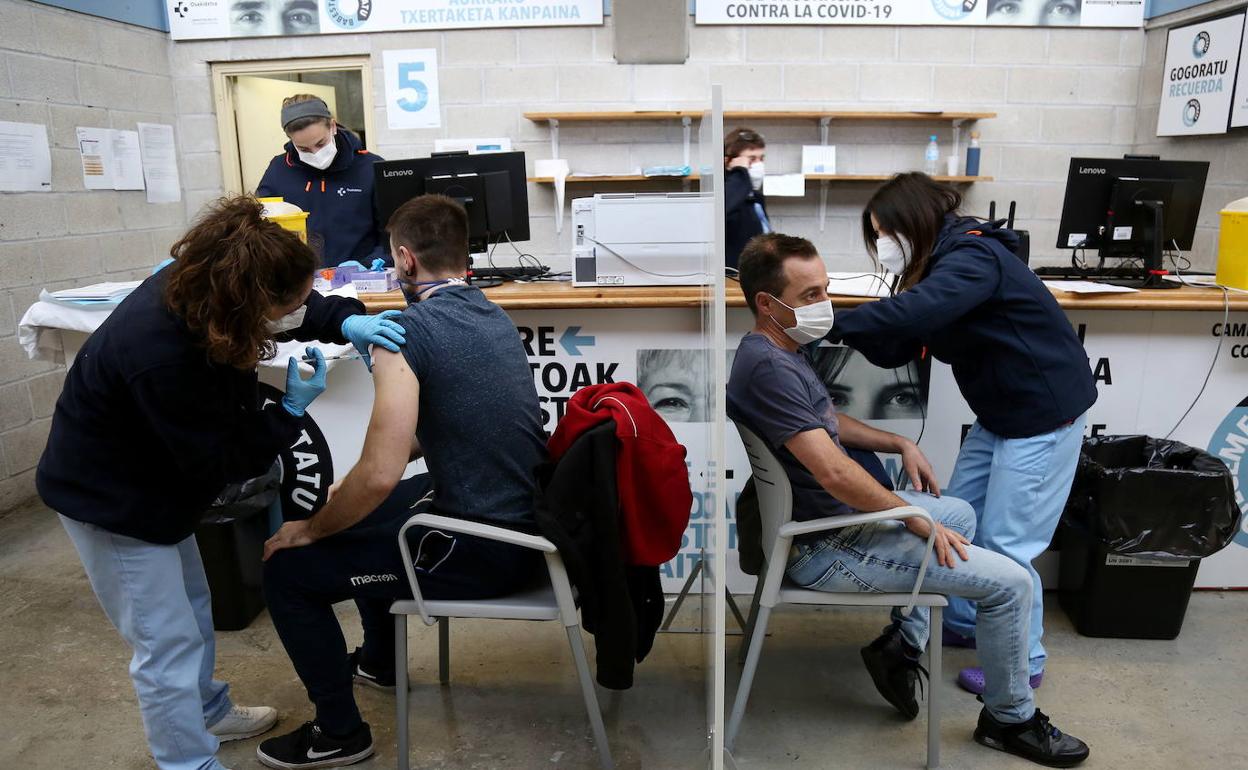 Dos hombres se vacunan en Illunbe con el suero anglosueco durante la inyección de las primeras dosis a colectivos esenciales. 