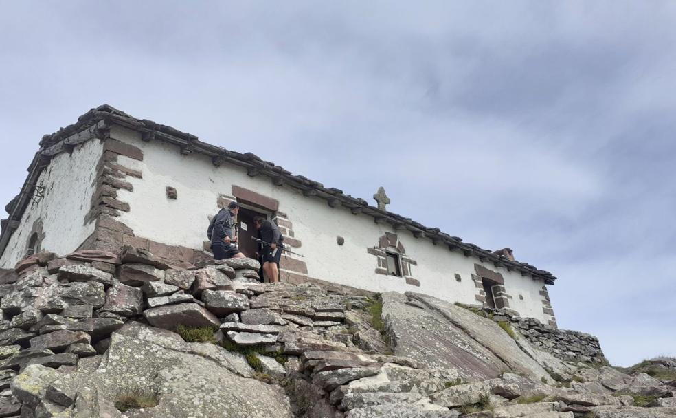 Dos mendizales abren la puerta de la ermita situada en la cima de Mendaur, en la que mañana se celebra su festividad.
