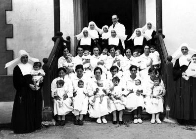 Imagen secundaria 1 - Nodrizas, madres e Hijas de la Caridad con el director Jesús Alústiza. Para evitar abandonos en la vía pública o infanticidios, crearon estos cilindros giratorios. Desde el exterior la madre colocaba al bebé, el torno giraba y activaba una alarma para que la criatura fuera recogida en el interior. Hubo en Donostia, Tolosa, Azpeitia y Bergara.
