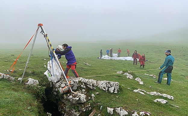 Un voluntario junto a la palanca con la que sacaron las bolsas llenas de basura de la sima.