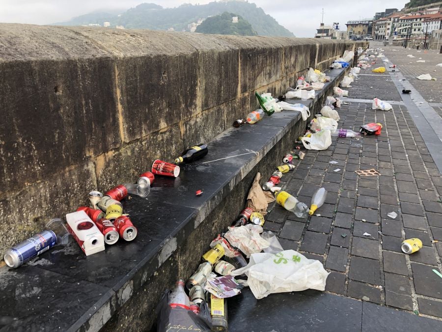 El puerto donostiarra ha amanecido cubierto de restos de plásticos y cristales después de una noche de botellón
