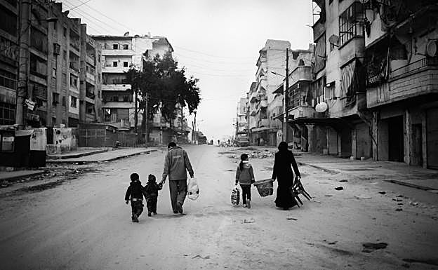 Imagen principal - Una familia abandona su hogar del barrio Al-Amriyah en Alepo en 2013. Retratos de dos refugiados que se encuentran en Donostia.