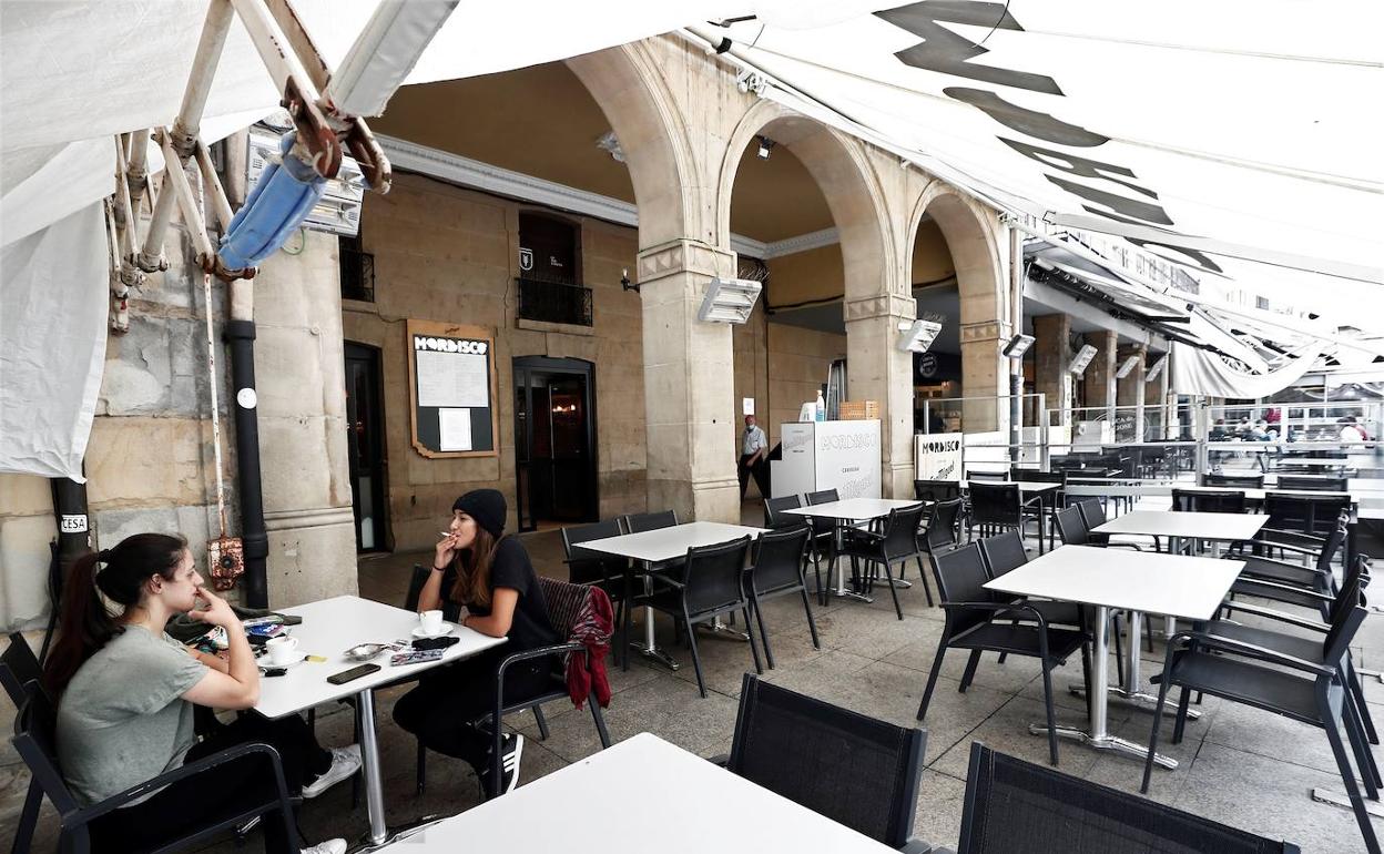 Dos personas en una terraza de la Plaza del Castillo en Pamplona. 