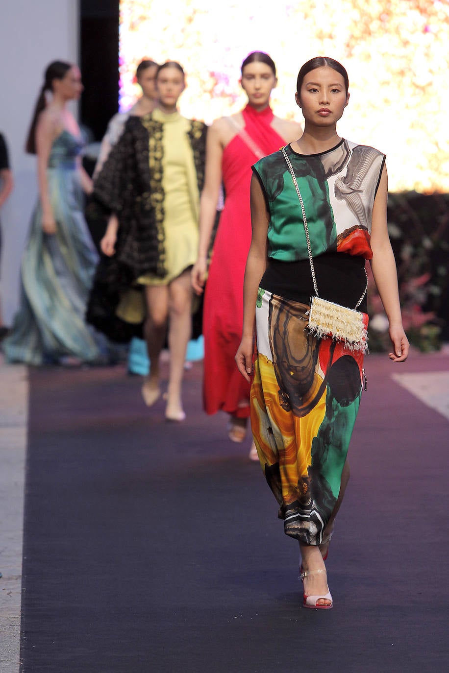 Bombers, sudaderas, camiseros, pantalones, faldas y camisetas se combinan de forma ecléctica en las propuestas de Isabel Zapardiez para afrontar los eventos de verano con garantías. La fusión es predominante también en los tejidos, que abarcan un amplio espectro. Se pueden ver satenes de seda natural, gasas, brocados y otros hilos tradicionales, pero también materiales sacados de su contexto, como el plástico de burbujas reciclado con el que la diseñadora confecciona piezas muy singulares. ¿Y la explosión y mezcla de colores? Todo un espectáculo. Inspírate gracias a la selección de propuestas presentada por la donostiarra en Oviedo