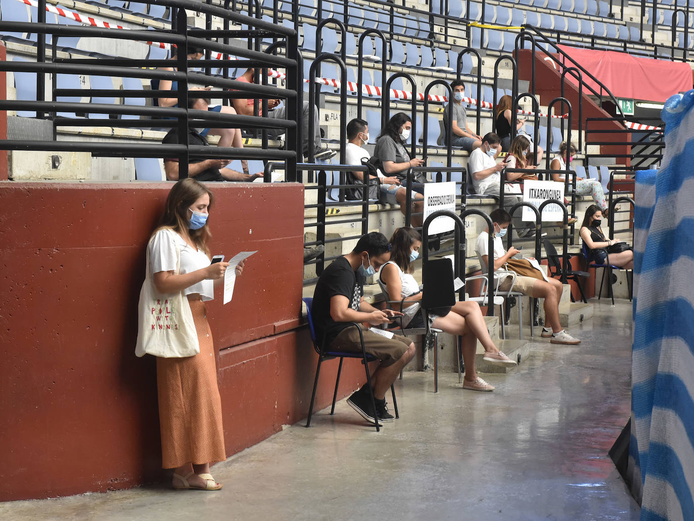 Varias personas esperan a que pasen los 15 minutos tras recibir la vacuna. 