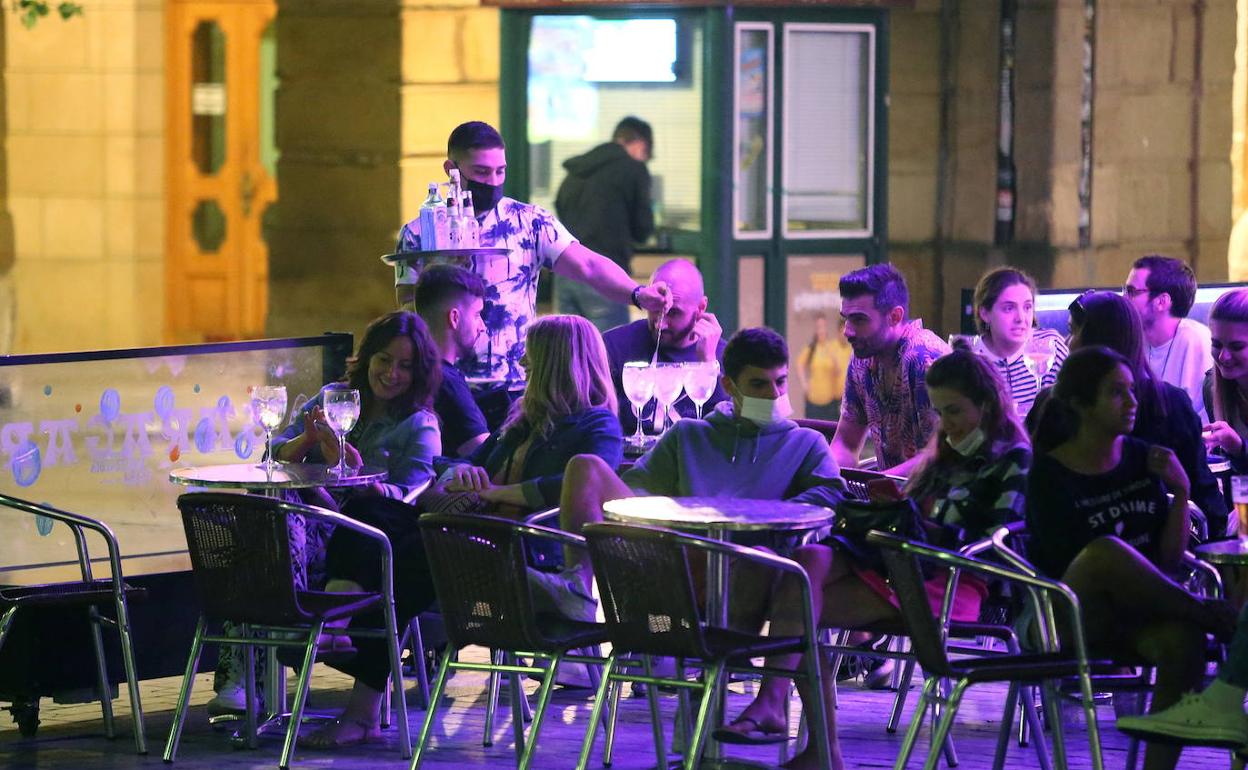 Un camarero sirve unas copas en una terraza de un bar de San Sebastián.
