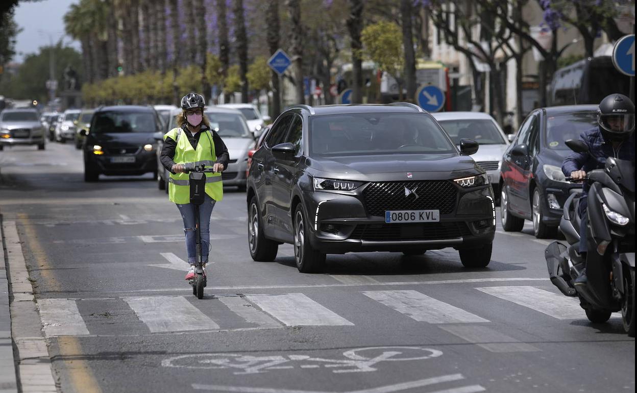 Una mujer avanza por el asfalto con un patín eléctrico.