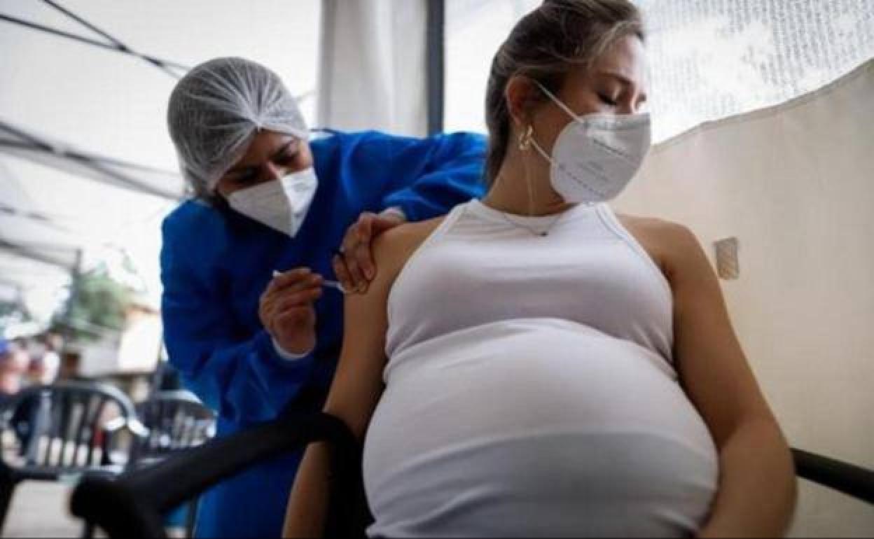 Una mujer embarazda poniéndose una vacuna
