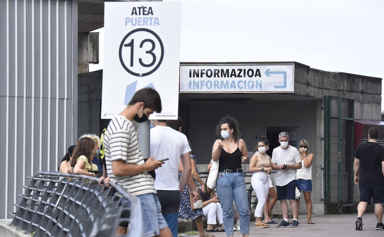 Jóvenes hacen cola en la puerta trece del vacunódromo de Illunbe para recibir el pinchazo.