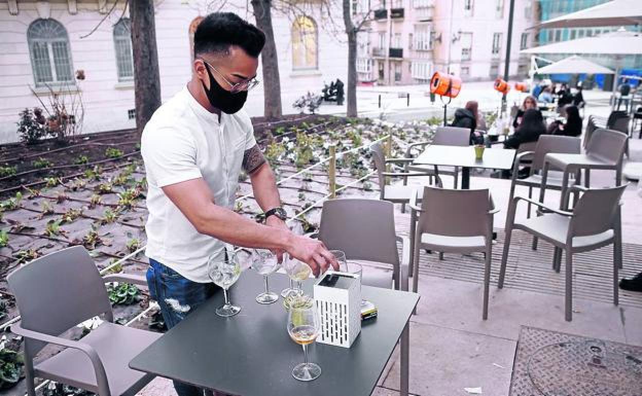 Un camarero recoje una mesa de una terraza en el casco viejo de Vitoria.