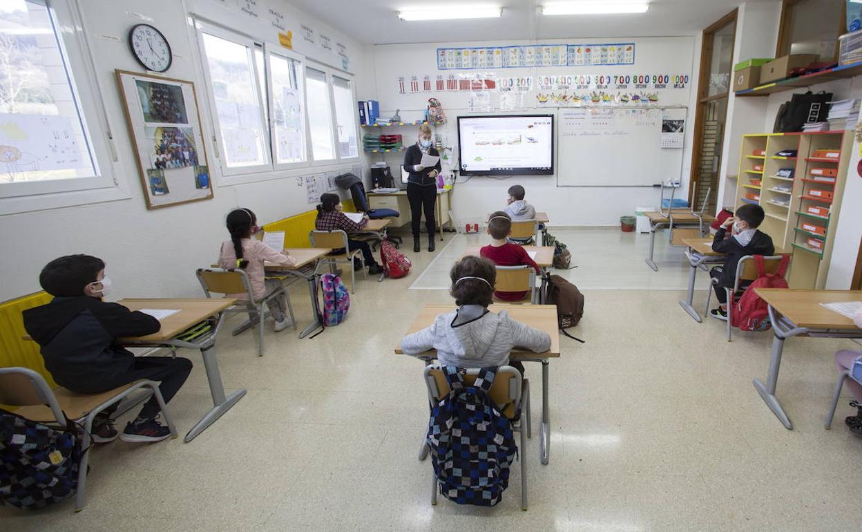 Alumnos siguen una clase manteniendo las distancias y con mascarillas.