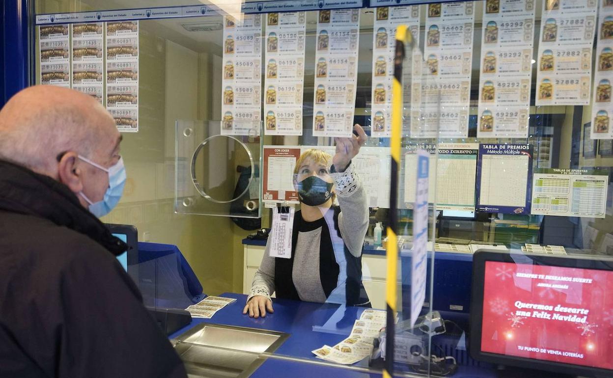 Un hombre compra lotería en una oficina, en una foto de archivo. 