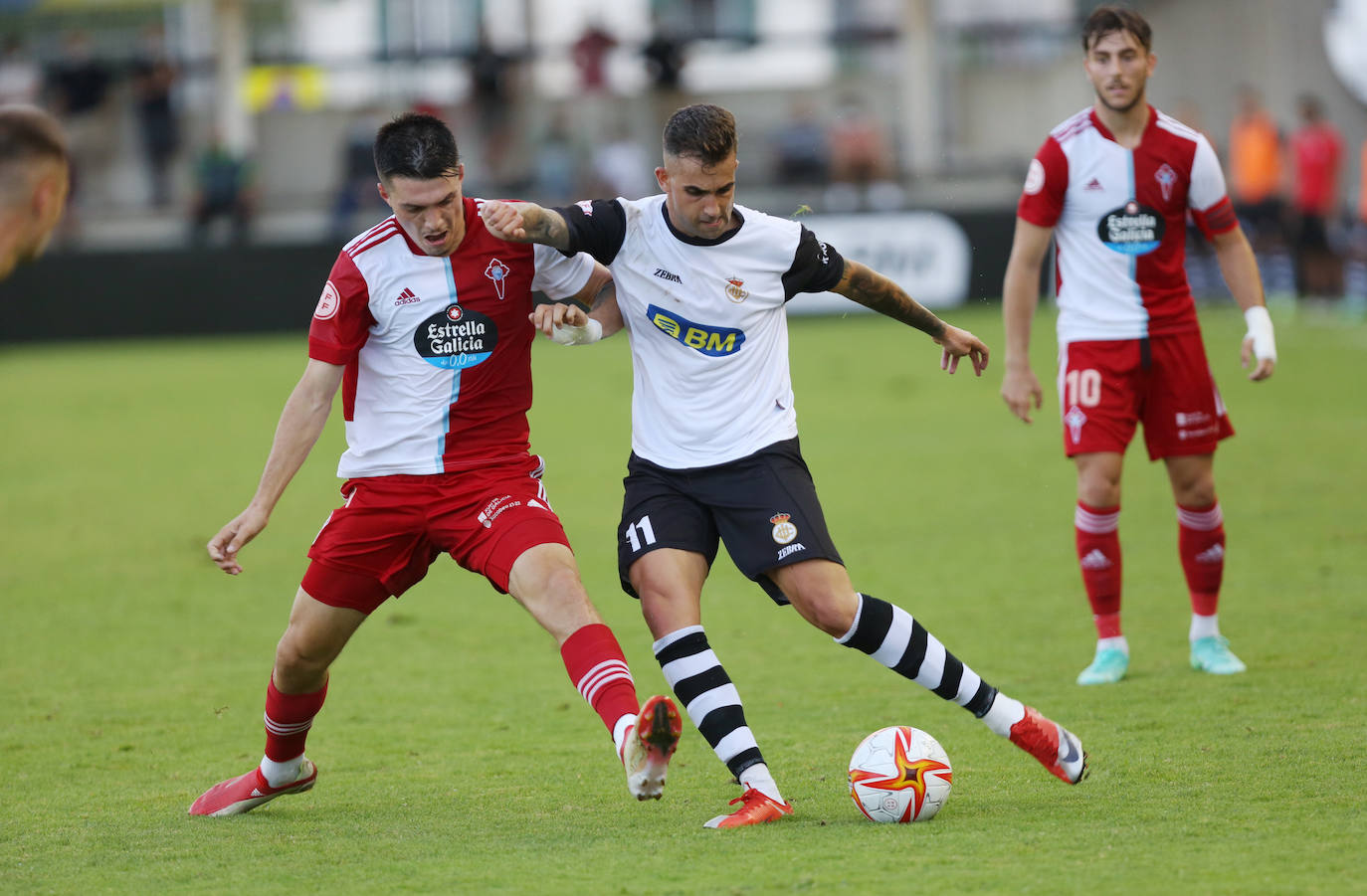 Alain Oyarzun golpea un balón presionado por un jugador gallego.