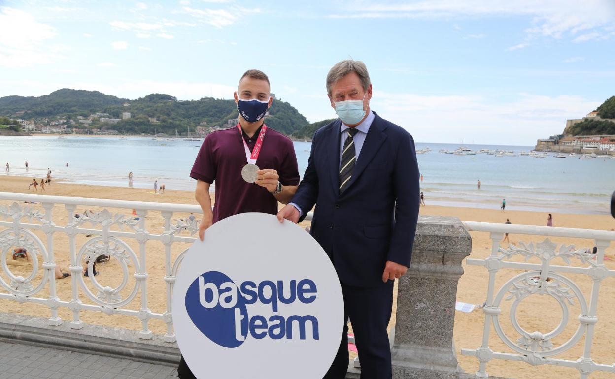 Iñigo Llopis, que sujeta la presea de plata, acompañado de Bingen Zupiria con el fondo de la bahía. 