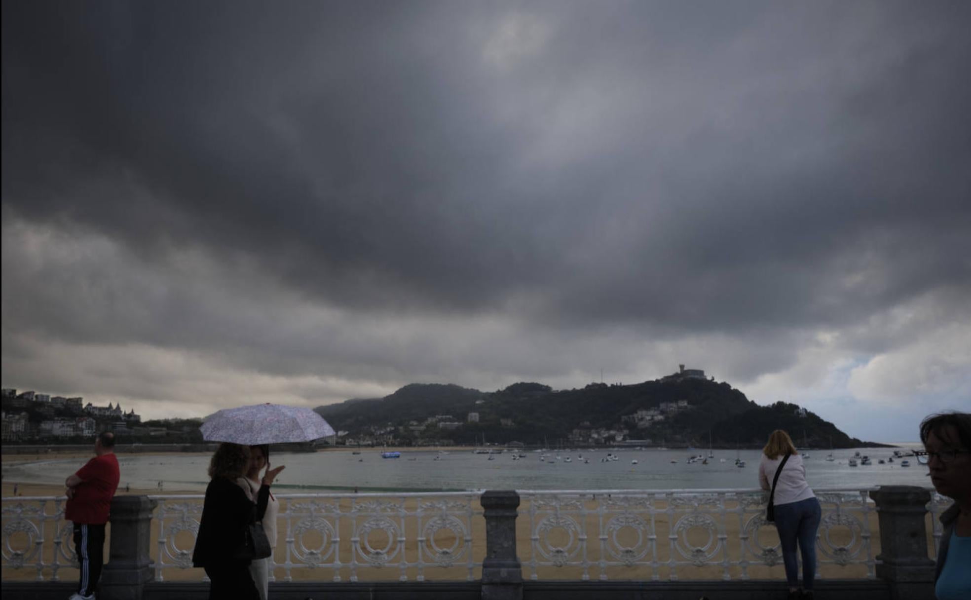 Paseantes ante la bahía de La Concha a última hora de la tarde de este miércoles.