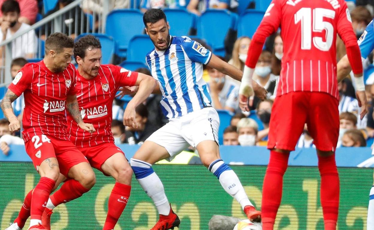 Merino protege el balón ante los jugadores del Sevilla. 