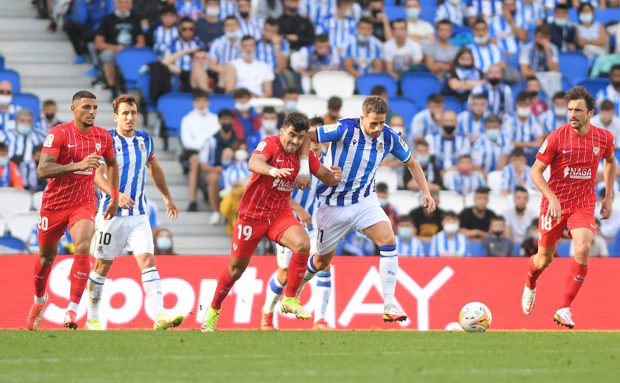 Adnan Januzaj trata de zafarse del marcaje del lateral izquierdo del Sevilla, Acuña.