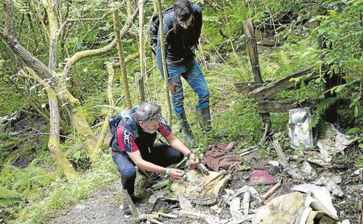 El bombero jubilado Alberto Bóveda observa los restos de una mascarilla de oxígeno junto al fotógrafo Rubén Santos. 