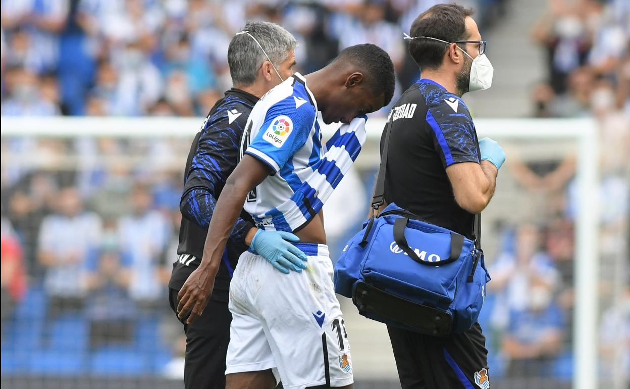 Isak se retira cabizbajo del césped acompañado por el médico Javier Barrera y el fisioterapeuta Imanol Soroa. 