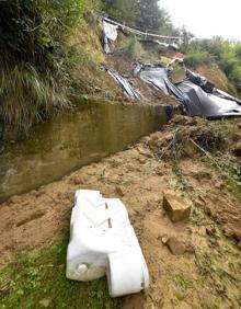 Imagen secundaria 2 - Estado de la calzada que sostiene la ladera y detalle del material caído desde la ladera. El impacto de la roca dejó a la vista el forjado de la fachada. 