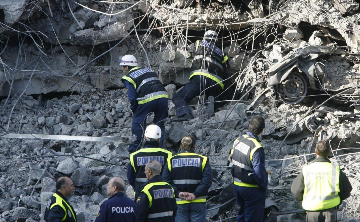 Un grupo de policías y bomberos trabaja en losescombros del módulo D de la T-4 para buscar a las dos personas desaparecidas tras el atentado con bombade ETA, que se produjo el 30 de diciembre de 2006. 