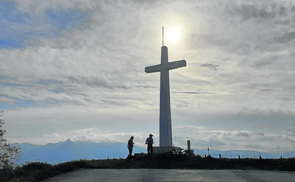 Vídeo: Imágenes del ascenso. Foto: Dos cicloturistas descansan junto a la cruz de Usurbe, junto a la que se encuentra el buzón de la cumbre. 