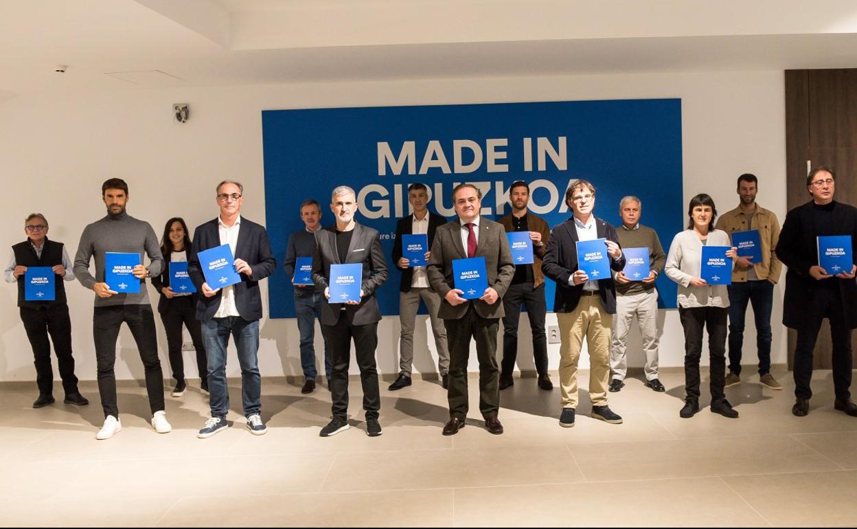 Exjugadores, técnicos y responsables de la Real encabezados por su presidente Aperribay posan con el libro presentado ayer en el Reale Arena. 