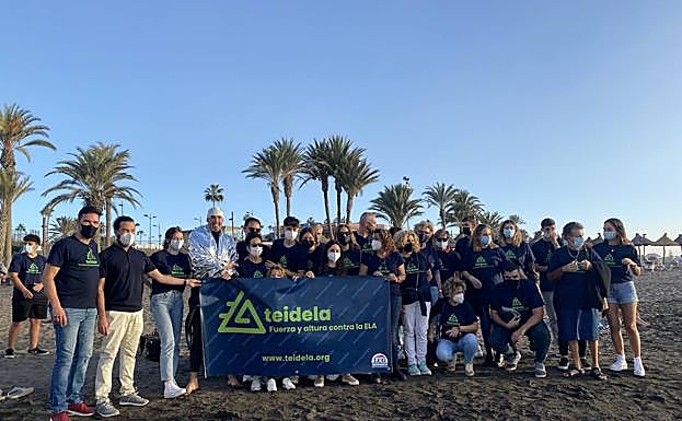 El nadador arropado por los afectados de ELA y sus familiares tras su llegada. 