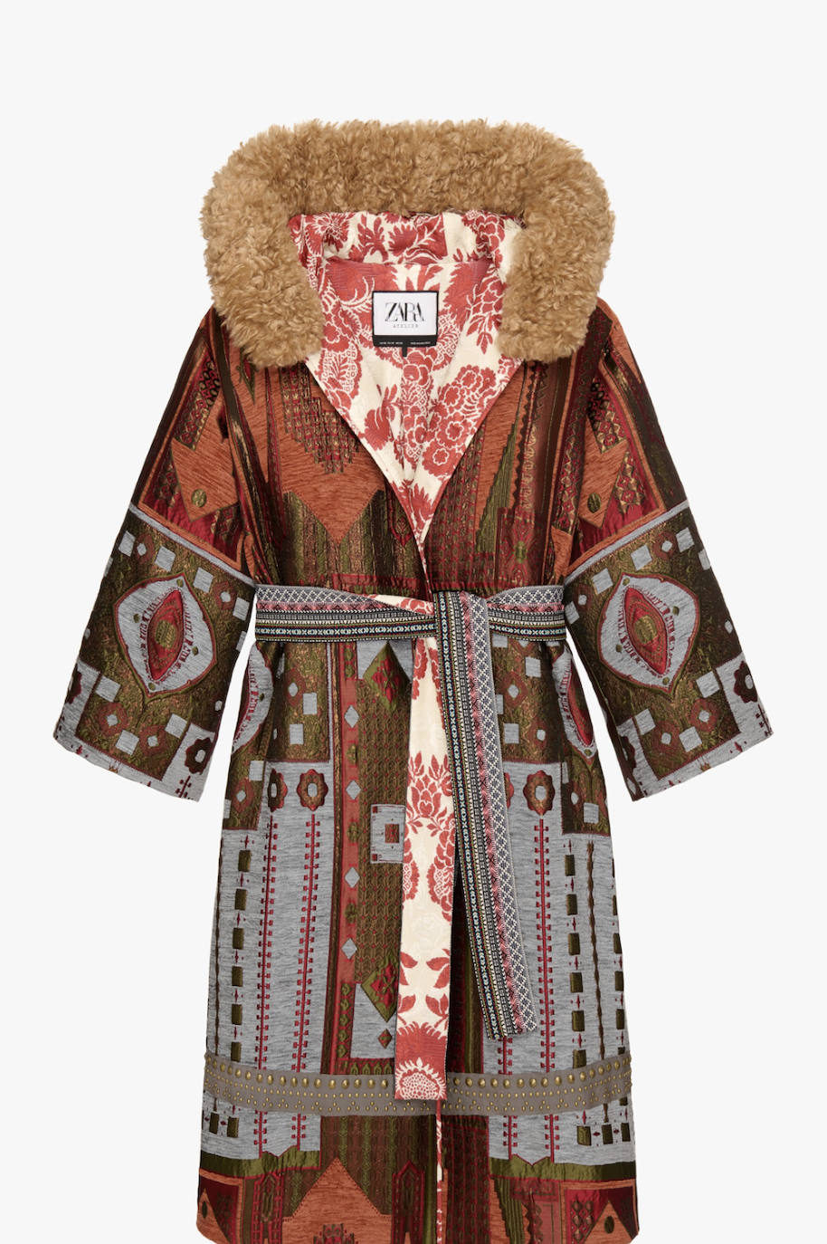 Este abrigo revestido de jacquard con hilo metalizado y punto de cruz nos ha apasionado. El pelo de la capucha es extraíble y el detalle de la cinta ancha de algodón con tachas piramidales de oro envejecido en el dobladillo es, simplemente, espectacular. Una de las cosas que más nos ha gustado es el forro interior con print floral a contraste con el exterior. Mix & match