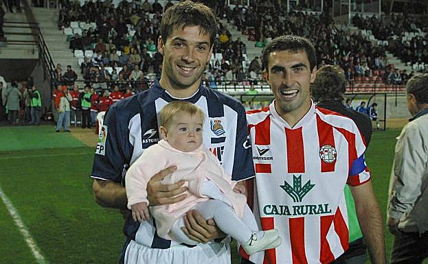Mikel Labaka sostiene a la hija de Igor San Miguel, con quien coincidió en su etapa en el Real Unión, antes del inicio de la eliminatoria de Copa de 2005.