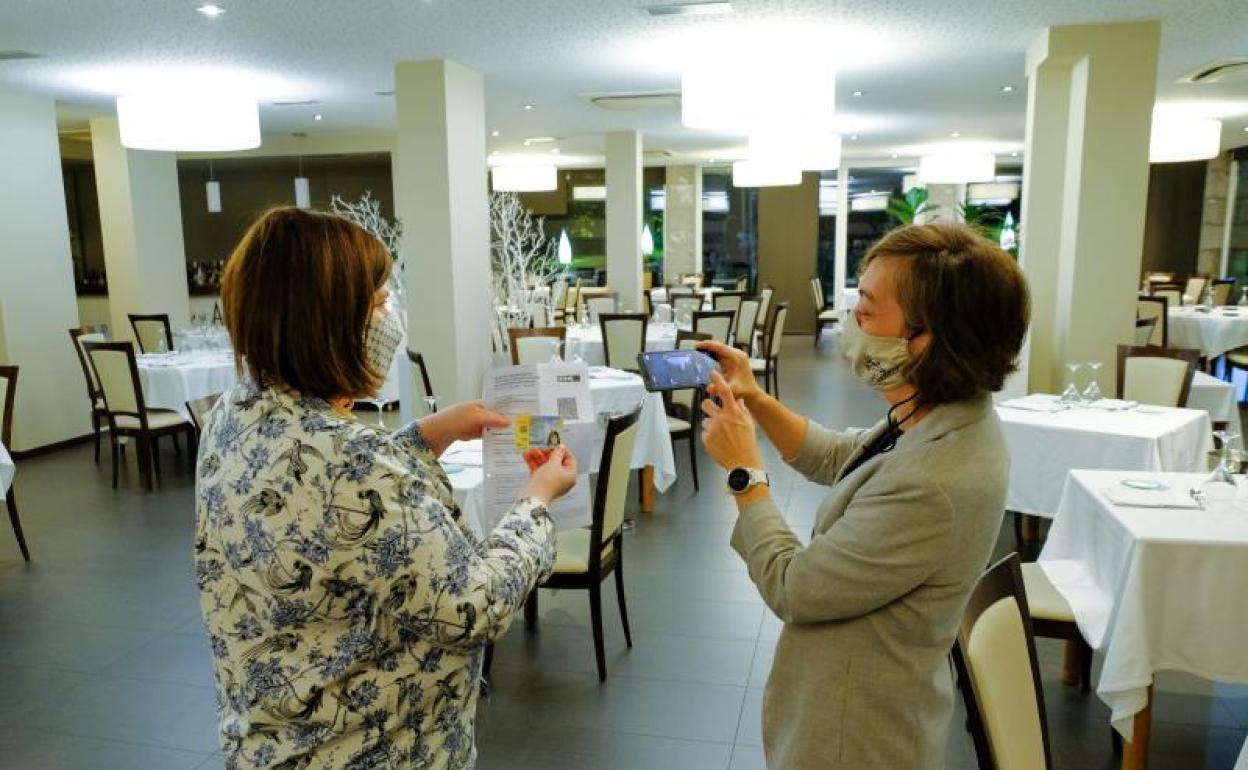 Una clienta muestra el pasaporte Covid en un restaurante de Irun.
