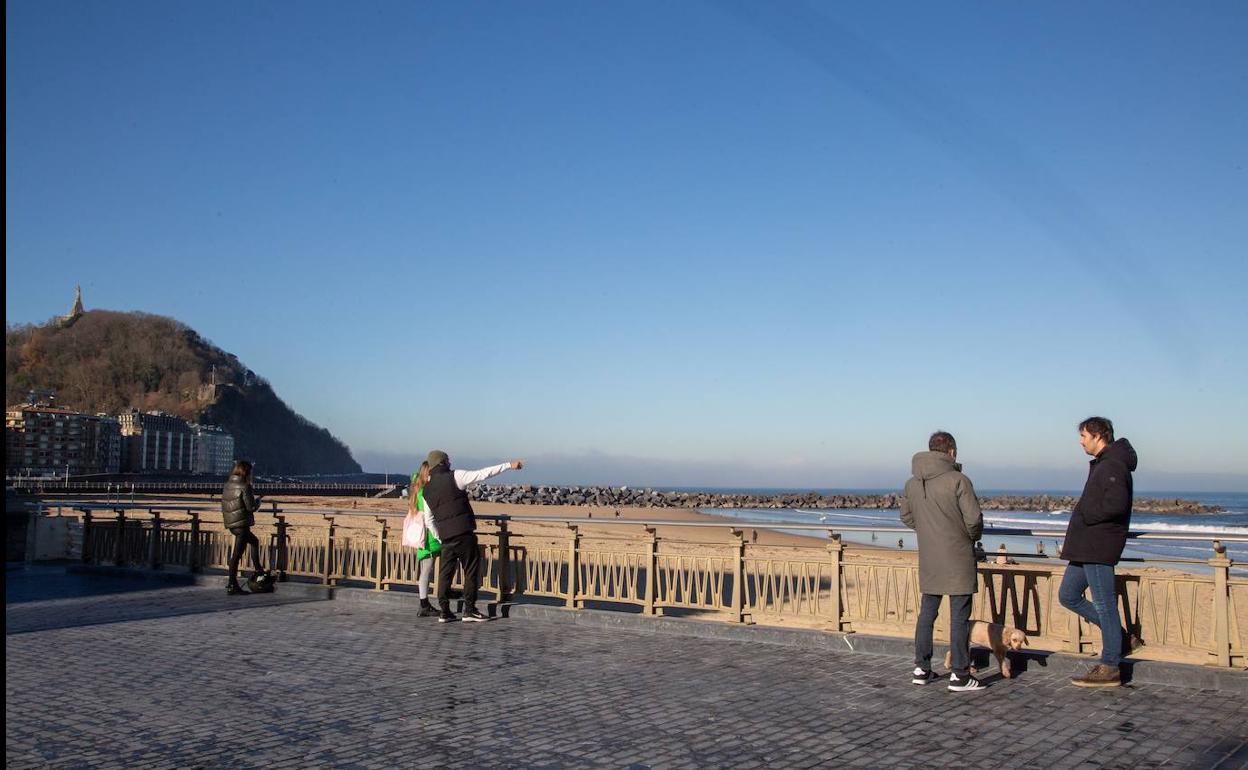 Gente disfrutando de la jornada soleada en la playa de la Zurriola.