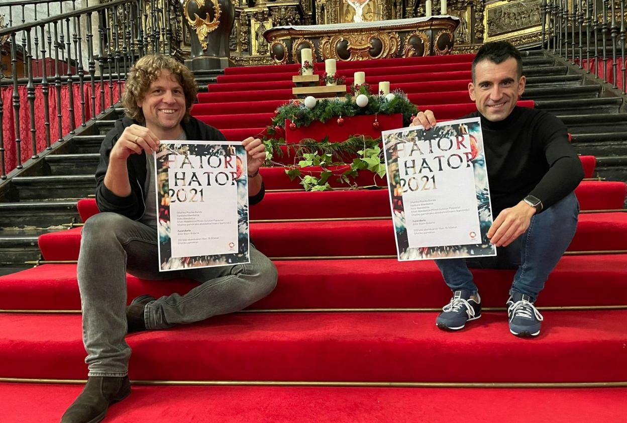 Manu Egaña y Aitor Biain sostienen el cartel del concierto de mañana. 