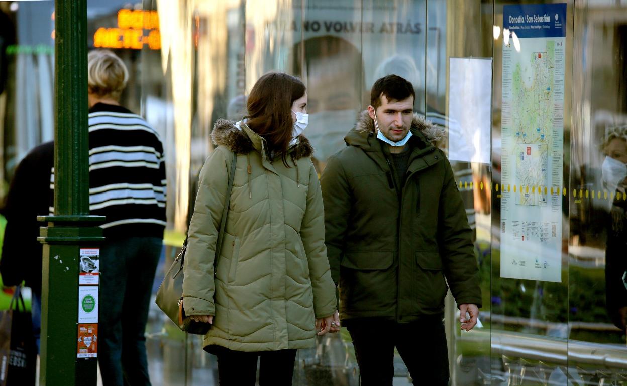 Dos jóvenes pasean ayer por Donostia con mascarilla, que desde mañana volverá a ser obligatoria al aire libre. 