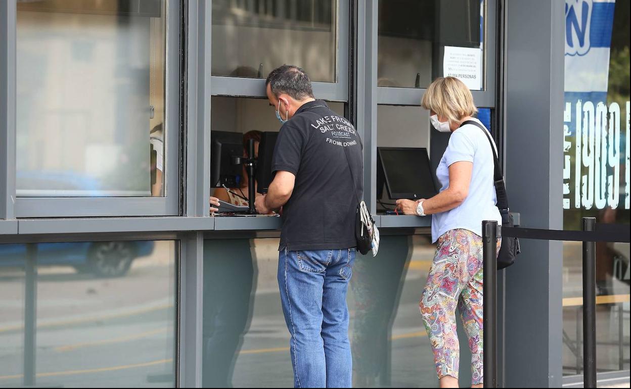 Dos aficionados dela Real Sociedad, comprando una entrada en el Reale Arena. 