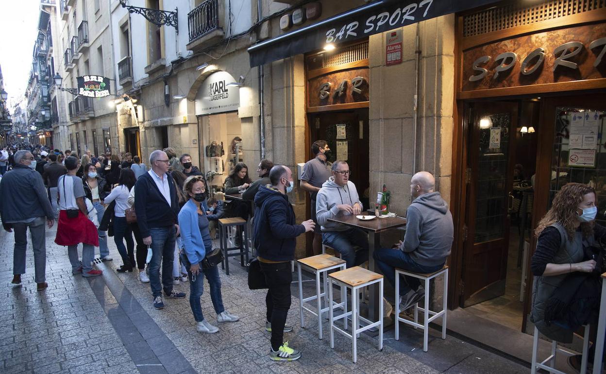 Un grupo de personas consumen en un bar de Donostia tras la entrada en vigor de las nuevas restricciones.