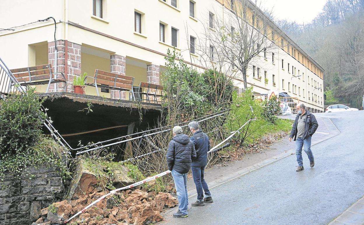 Varios vecinos observan el socavón.