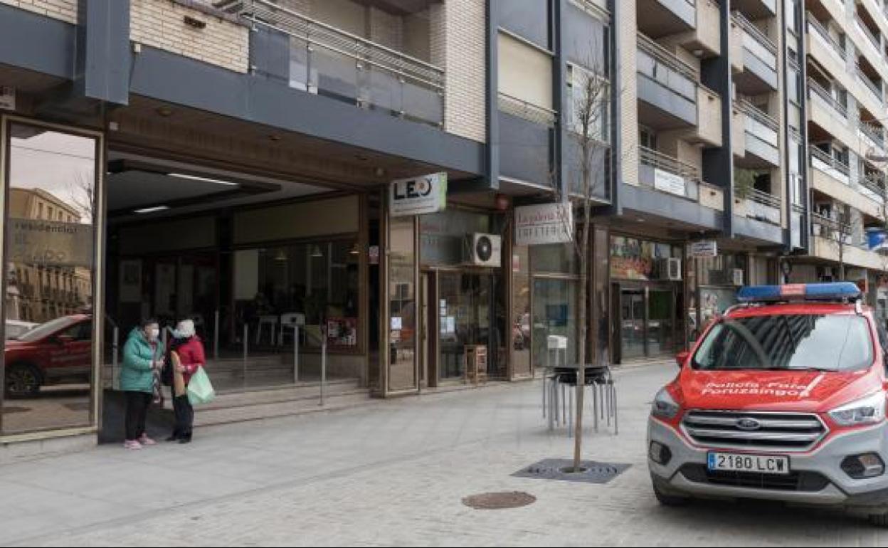 Un coche de la Policía Foral, ante la entrada a los portales del número 14 del paseo Pamplona
