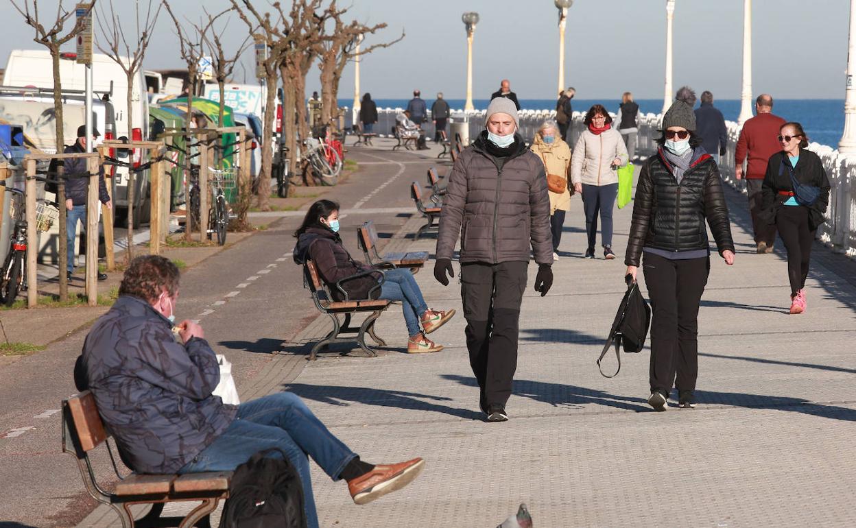 Viandantes disfrutan de un día soleado en Donostia. 