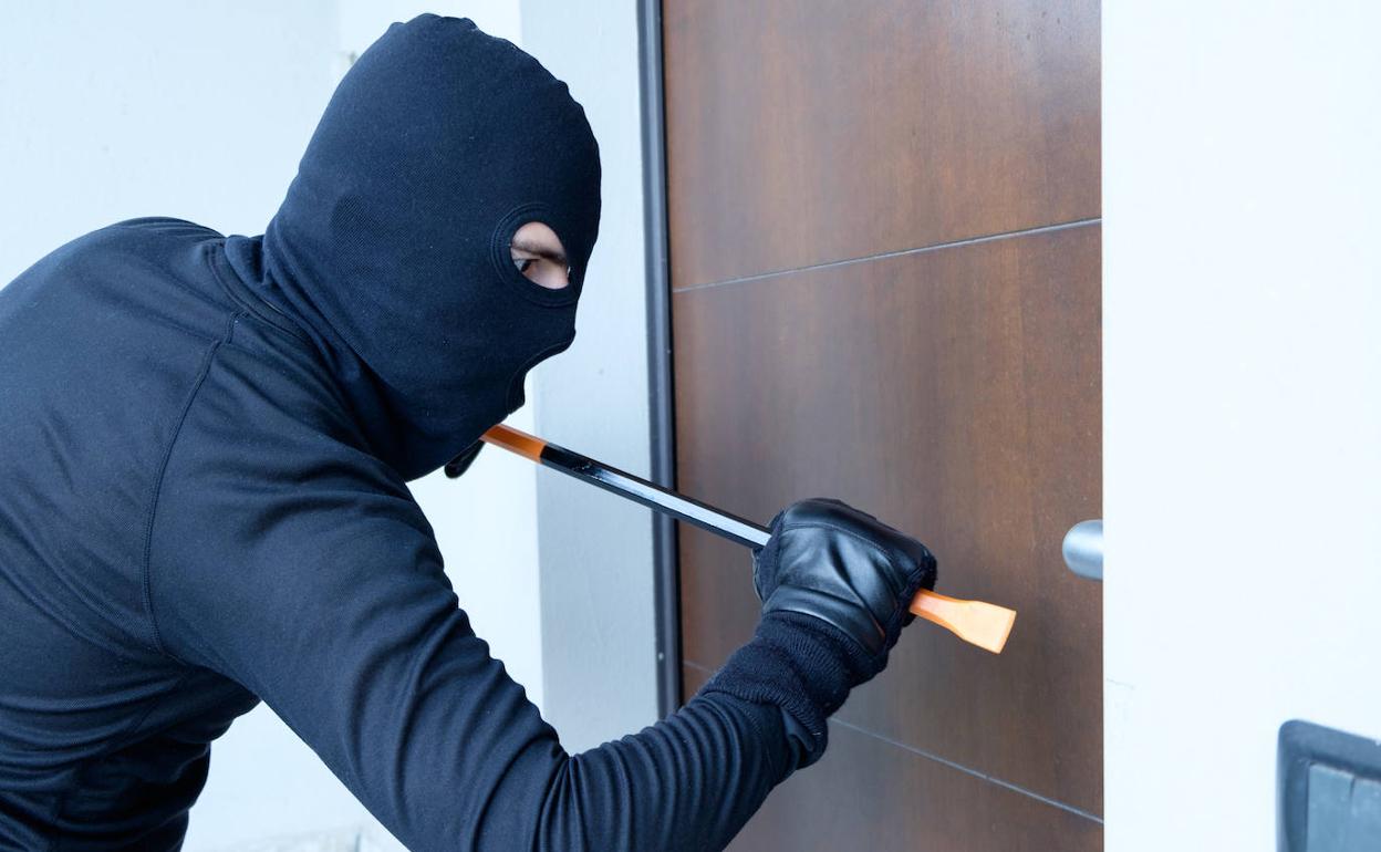 Un encapuchado trata de forzar la puerta de una vivienta.