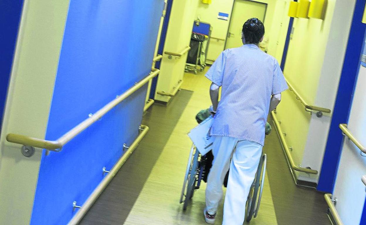 Un enfermero traslada a un residente en un centro de mayores.